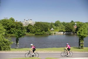 Cycling past Palace House and the Mill Pond in Beaulieu