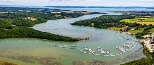 Aerial view of Buckler's Hard Yacht Harbour and Beaulieu River moorings stretching down to the Solent