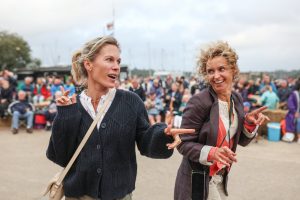 Two mooring holders dancing in the boatyard in front of a crowd