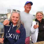 Three mooring holders smiling for the camera in front of the river